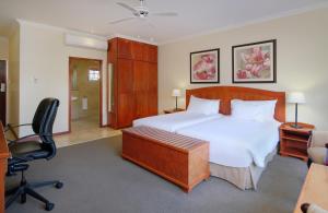 a bedroom with a bed and a desk and a chair at Protea Hotel by Marriott Polokwane Ranch Resort in Polokwane