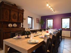 ein großes Esszimmer mit einem langen Tisch und Stühlen in der Unterkunft Cottage with swimming pool in Weismes