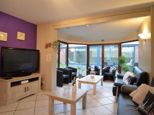 ein Wohnzimmer mit Sofas und einem Flachbild-TV in der Unterkunft Cottage with swimming pool in Weismes