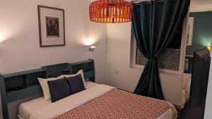 een slaapkamer met een bed en een zwart gordijn bij Aux Écuries Des Pres in Nogent-sur-Seine