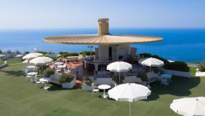 een uitzicht over een resort met tafels en parasols bij Grand Hotel Pianeta Maratea Resort in Maratea