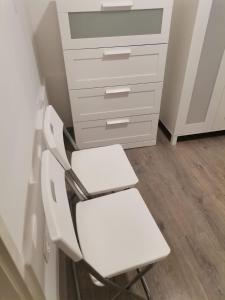 a white chair in a room with a dresser at Quiet Residential @ Agglomeration Taplanszentkereszt 2 Bedroom + Living room in Szombathely