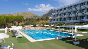 a hotel with a swimming pool with chairs and umbrellas at Grand Hotel Pianeta Maratea Resort in Maratea