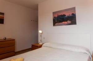 1 dormitorio con 1 cama, vestidor y una foto en Casa de Eva en Matalascañas, en Matalascañas
