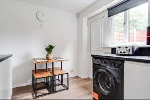 a laundry room with a washer and dryer at Newly renovated house near Trafford Centre in Manchester