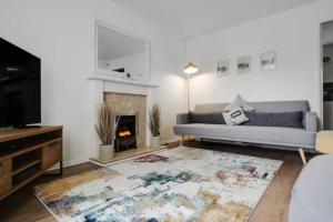 a living room with a couch and a fireplace at Newly renovated house near Trafford Centre in Manchester