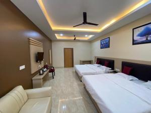 een hotelkamer met 2 bedden en een bank bij GRACE INN GUEST HOUSE, Near Airport and Ion Digital in Guwahati