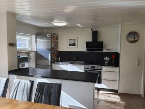 uma cozinha com electrodomésticos brancos e uma bancada preta em Ferienhaus Erlengrund em Staphel