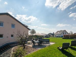 a patio with a table and chairs in a yard at Lovely modern apartment with private terrace in Ellscheid