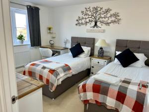 ein Schlafzimmer mit 2 Betten und einem Baum an der Wand in der Unterkunft Driver Way in Wellingborough