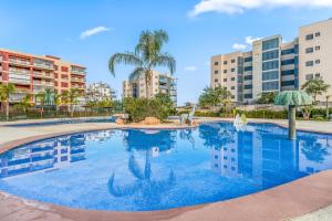 uma grande piscina com palmeiras e edifícios em Apartamento Gran Terraza Vistas Mar em Pilar de la Horadada