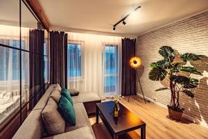 a living room with a couch and a plant at Elegance Loft Apartment in Skoczów