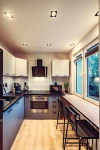 a kitchen with white cabinets and a table and chairs at Elegance Loft Apartment in Skoczów