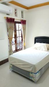 1 dormitorio con 1 cama en una habitación con ventana en Private Bali Artifac GuestHouse, en Singaraja