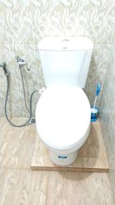 a white toilet in a bathroom with a hose at Private Bali Artifac GuestHouse in Singaraja