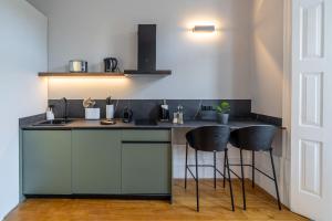 a kitchen with a counter and two stools at Limehome Porto Rua de Dom Manuel II in Porto