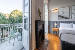 a bedroom with a bed and a balcony with a fireplace at Limehome Porto Rua de Dom Manuel II in Porto