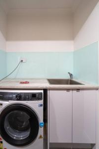 布里斯班Relaxation 2BR/1.5BA House w Parking near Beach的配有洗衣机和水槽的厨房