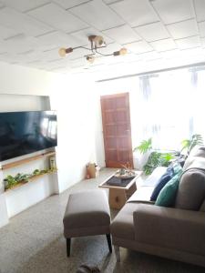 a living room with a couch and a tv at Alquiler Casa con pileta in Godoy Cruz