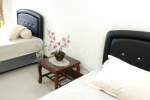 een slaapkamer met een bed en een tafel met een plant erop bij Private Bali Artifac GuestHouse in Singaraja