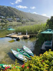 three canoes are parked at a dock on a lake at Moontide Riverside Lodge in Wilderness