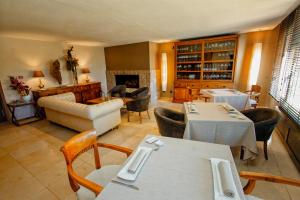 a restaurant with tables and chairs and a living room at Hotel Swiss Moraira in Moraira