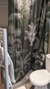 a bathroom with a black and white shower curtain at Aux Écuries Des Pres in Nogent-sur-Seine