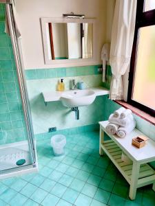 een blauwe betegelde badkamer met een wastafel en een douche bij Capanna 1826 in San Gimignano