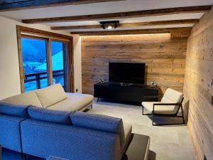 a living room with a couch and a television at Chalet L'Alpaga in Châtel