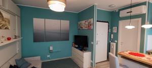 a living room with blue walls and a television at L'Alloggetto sul Corso in Cuneo