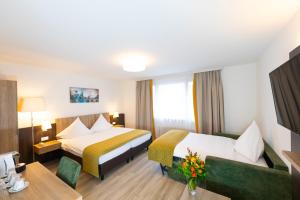 Habitación de hotel con cama y sofá en Hotel Alfa, en Basilea