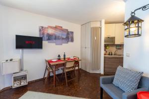 een woonkamer met een tafel en een keuken bij [SESTRIERE] Appartamento sulle piste in Sestriere
