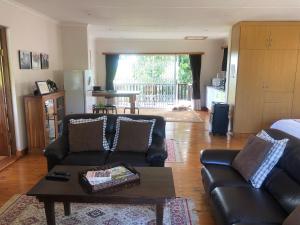 a living room with a couch and a table at Bee’s Knees Cottage in Winterton +11 photos