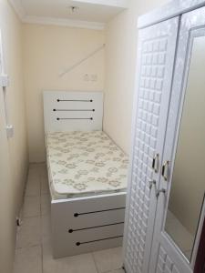 a small white closet with a bed and a door at Partition Rooms in Hotel Apartment in Dubai