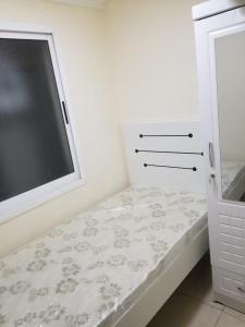 - une petite chambre avec un lit et une fenêtre dans l'établissement Partition Rooms in Hotel Apartment, à Dubaï