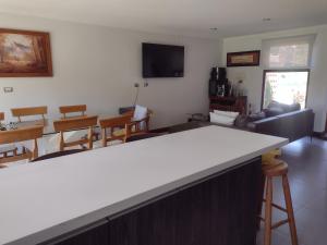 a kitchen and dining room with a white counter top at Pingueral Casa 07 in Dichato