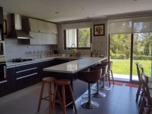 a kitchen with a large island with bar stools at Pingueral Casa 07 in Dichato