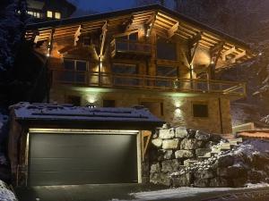 a log house with a garage in the snow at Chalet L'Alpaga in Châtel