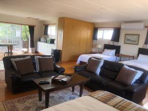 a living room with a couch and a bed at Bee’s Knees Cottage in Winterton