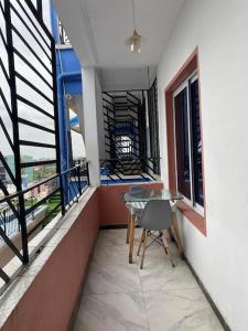 a balcony with a table and some windows at Appartement famille 03 chambres in Douala