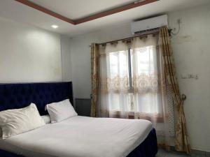 a bedroom with a large bed with a window at Appartement famille 03 chambres in Douala