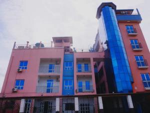 a tall building with blue windows and balconies at Appartement famille 03 chambres in Douala