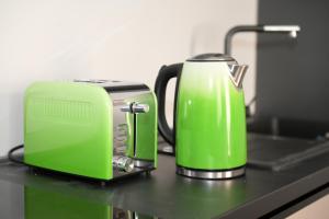 a green toaster and a toaster on a counter at City Center Luxury 2 Bedroom in Bucharest