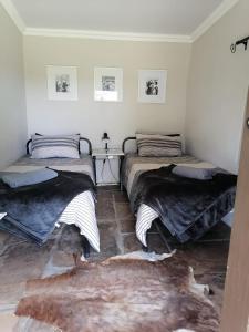 2 Betten in einem Zimmer mit einem Teppich in der Unterkunft Bundu Camp in Heilbron