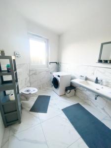 a white bathroom with a sink and a toilet at Ferienwohnung Zum Alten Radlereck in Lauchhammer