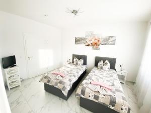 a bedroom with two beds and a tv at Ferienwohnung Zum Alten Radlereck in Lauchhammer