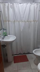 uma casa de banho com uma cortina de chuveiro branca e um lavatório. em TEMPORARIO RIVADAVIA em Corrientes