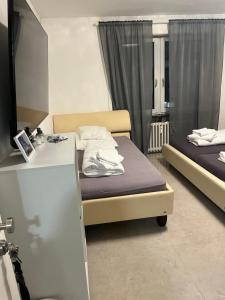 a room with two beds and a desk with a counter at House Cologne in Cologne