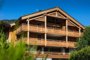 a large wooden building with a large deck at Les Chalets PVG in La Clusaz