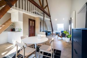 een keuken en een woonkamer met een witte tafel en stoelen bij General Sixty-Seven by Romy&Travis in Brugge